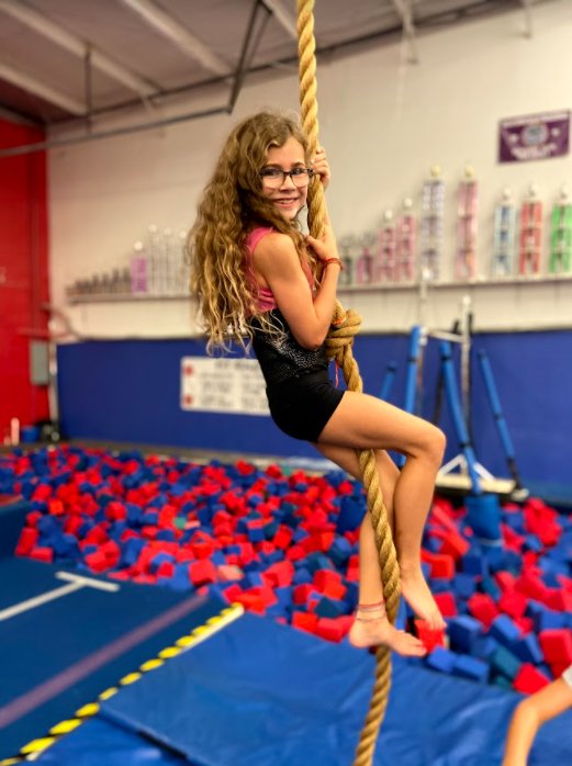 child climbing rope in gymnastics gym