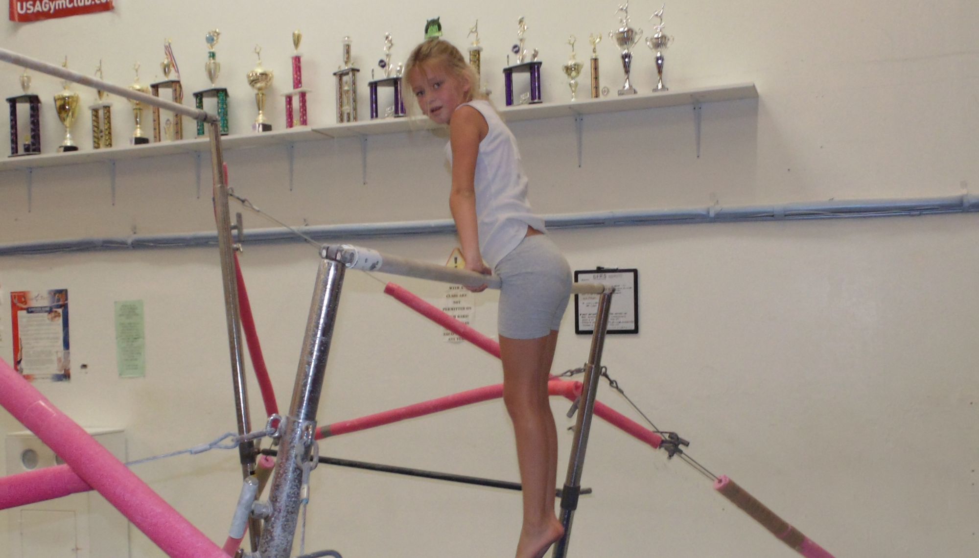 child practicing on the uneven bars