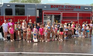 children standing in front of a fire truck