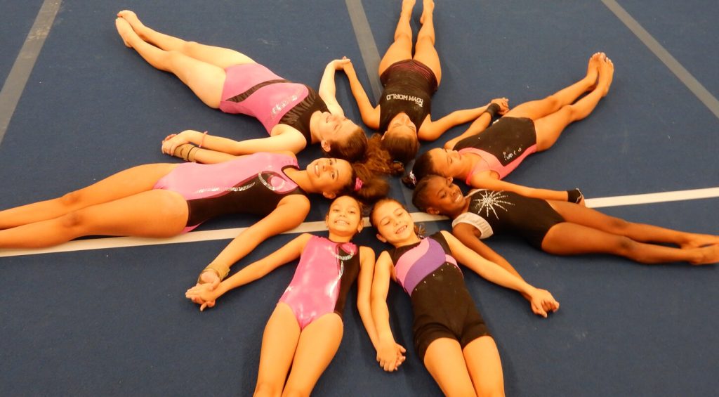 gymnastics children laying on mat in the shape of star
